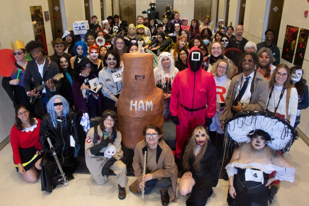 Students and faculty from the American Academy of Art College posing as a group in their Halloween costumes.